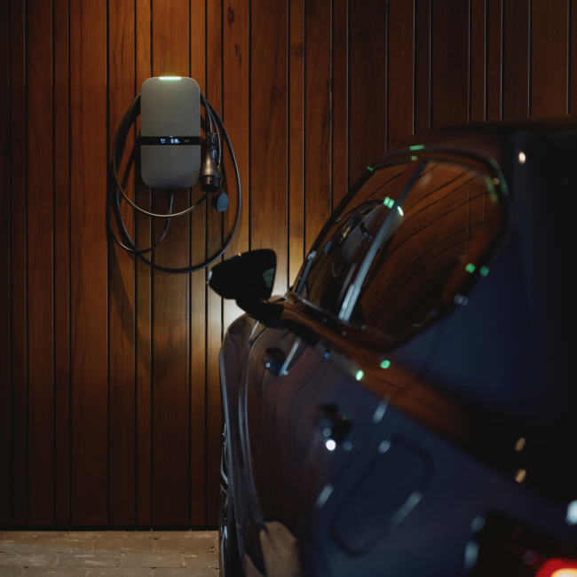 Peblar laadpaal met vaste kabel naast een elektrische auto